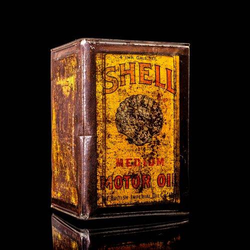Vintage Shell oil cans with red and yellow branding from the 1900-1920 old logo Vintage Shell oil cans from 1900-19255, featuring the old logo. The photo showcases an antique tin red with yellow accents, displaying the historic Shell emblem. Shot in a studio against a solid black background