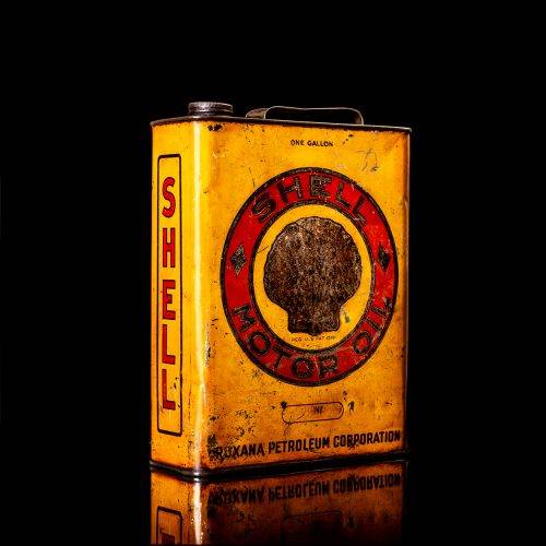 Vintage Shell oil cans with red and yellow branding from the 1900-1920 old logo Vintage Shell oil cans from 1900-19255, featuring the old logo. The photo showcases an antique tin red with yellow accents, displaying the historic Shell emblem. Shot in a studio against a solid black background