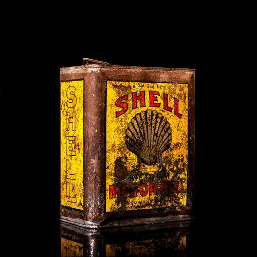 Vintage Shell oil cans with red and yellow branding from the 1900-1920 old logo Vintage Shell oil cans from 1900-19255, featuring the old logo. The photo showcases an antique tin red with yellow accents, displaying the historic Shell emblem. Shot in a studio against a solid black background