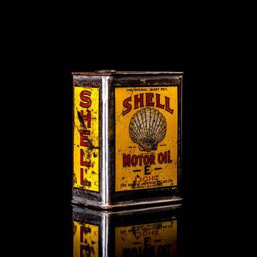 Vintage Shell oil cans with red and yellow branding from the 1900-1920 old logo Vintage Shell oil cans from 1900-19255, featuring the old logo. The photo showcases an antique tin red with yellow accents, displaying the historic Shell emblem. Shot in a studio against a solid black background