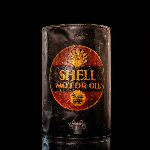 Vintage Shell oil cans with red and yellow branding from the 1900-1920 old logo Vintage Shell oil cans from 1900-19255, featuring the old logo. The photo showcases an antique tin red with yellow accents, displaying the historic Shell emblem. Shot in a studio against a solid black background