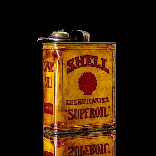 Vintage Shell oil cans with red and yellow branding from the 1900-1920 old logo Vintage Shell oil cans from 1900-19255, featuring the old logo. The photo showcases an antique tin red with yellow accents, displaying the historic Shell emblem. Shot in a studio against a solid black background