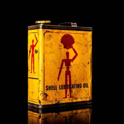 Vintage Shell oil cans with red and yellow branding from the 1900-1920 old logo Vintage Shell oil cans from 1900-19255, featuring the old logo. The photo showcases an antique tin red with yellow accents, displaying the historic Shell emblem. Shot in a studio against a solid black background