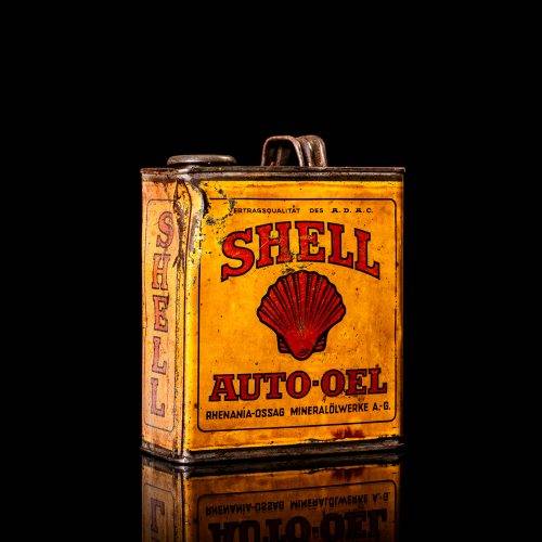 Vintage Shell oil cans with red and yellow branding from the 1900-1920 old logo Vintage Shell oil cans from 1900-19255, featuring the old logo. The photo showcases an antique tin red with yellow accents, displaying the historic Shell emblem. Shot in a studio against a solid black background