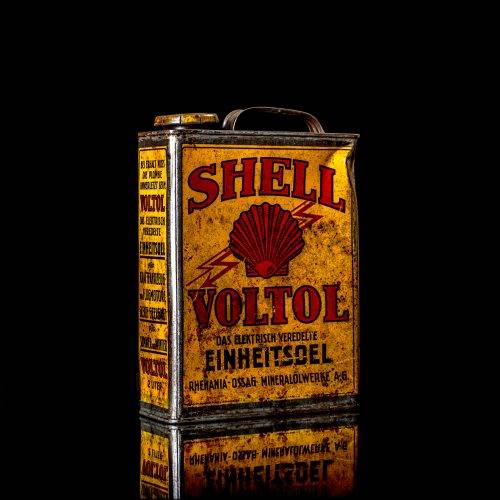 Vintage Shell oil cans with red and yellow branding from the 1900-1920 old logo Vintage Shell oil cans from 1900-19255, featuring the old logo. The photo showcases an antique tin red with yellow accents, displaying the historic Shell emblem. Shot in a studio against a solid black background