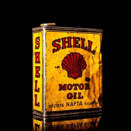 Vintage Shell oil cans with red and yellow branding from the 1900-1920 old logo Vintage Shell oil cans from 1900-19255, featuring the old logo. The photo showcases an antique tin red with yellow accents, displaying the historic Shell emblem. Shot in a studio against a solid black background