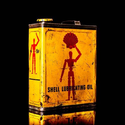 Vintage Shell oil cans with red and yellow branding from the 1900-1920 old logo Vintage Shell oil cans from 1900-19255, featuring the old logo. The photo showcases an antique tin red with yellow accents, displaying the historic Shell emblem. Shot in a studio against a solid black background