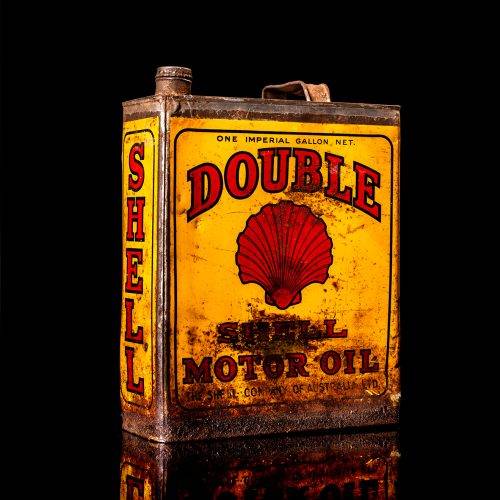 Vintage Shell oil cans with red and yellow branding from the 1900-1920 old logo Vintage Shell oil cans from 1900-19255, featuring the old logo. The photo showcases an antique tin red with yellow accents, displaying the historic Shell emblem. Shot in a studio against a solid black background