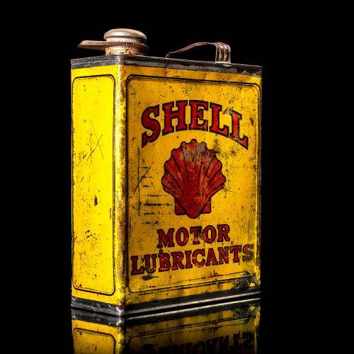 Vintage Shell oil cans with red and yellow branding from the 1900-1920 old logo Vintage Shell oil cans from 1900-19255, featuring the old logo. The photo showcases an antique tin red with yellow accents, displaying the historic Shell emblem. Shot in a studio against a solid black background