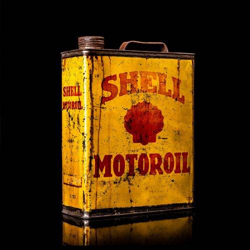 Vintage Shell oil cans with red and yellow branding from the 1900-1920 old logo Vintage Shell oil cans from 1900-19255, featuring the old logo. The photo showcases an antique tin red with yellow accents, displaying the historic Shell emblem. Shot in a studio against a solid black background