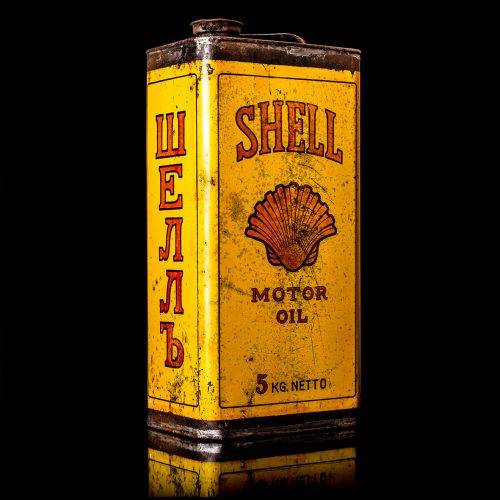 Vintage Shell oil cans with red and yellow branding from the 1900-1920 old logo Vintage Shell oil cans from 1900-19255, featuring the old logo. The photo showcases an antique tin red with yellow accents, displaying the historic Shell emblem. Shot in a studio against a solid black background