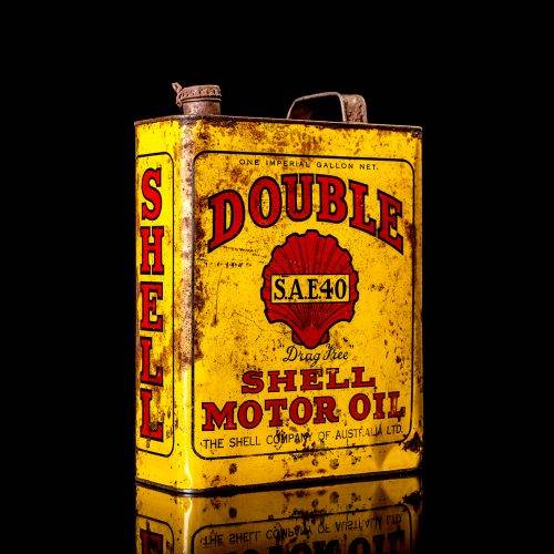 Vintage Shell oil cans with red and yellow branding from the 1900-1920 old logo Vintage Shell oil cans from 1900-19255, featuring the old logo. The photo showcases an antique tin red with yellow accents, displaying the historic Shell emblem. Shot in a studio against a solid black background