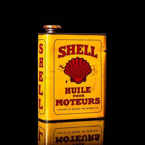 Vintage Shell oil cans with red and yellow branding from the 1900-1920 old logo Vintage Shell oil cans from 1900-19255, featuring the old logo. The photo showcases an antique tin red with yellow accents, displaying the historic Shell emblem. Shot in a studio against a solid black background