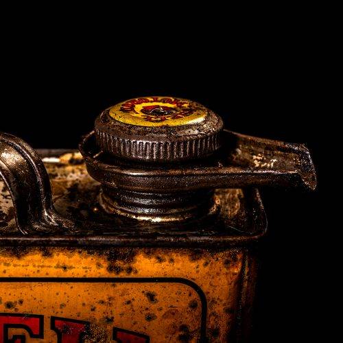 Vintage Shell oil cans with red and yellow branding from the 1900-1920 old logo Vintage Shell oil cans from 1900-19255, featuring the old logo. The photo showcases an antique tin red with yellow accents, displaying the historic Shell emblem. Shot in a studio against a solid black background