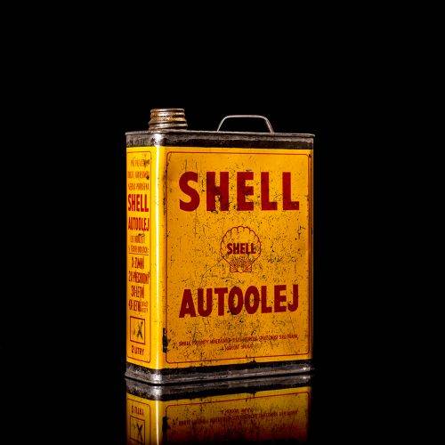Vintage Shell oil cans with red and yellow branding from the 1900-1920 old logo Vintage Shell oil cans from 1900-19255, featuring the old logo. The photo showcases an antique tin red with yellow accents, displaying the historic Shell emblem. Shot in a studio against a solid black background