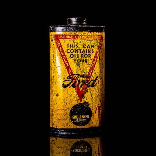 Vintage Shell oil cans with red and yellow branding from the 1900-1920 old logo Vintage Shell oil cans from 1900-19255, featuring the old logo. The photo showcases an antique tin red with yellow accents, displaying the historic Shell emblem. Shot in a studio against a solid black background