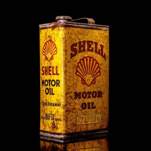 Vintage Shell oil cans with red and yellow branding from the 1900-1920 old logo Vintage Shell oil cans from 1900-19255, featuring the old logo. The photo showcases an antique tin red with yellow accents, displaying the historic Shell emblem. Shot in a studio against a solid black background