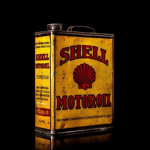 Vintage Shell oil cans with red and yellow branding from the 1900-1920 old logo Vintage Shell oil cans from 1900-19255, featuring the old logo. The photo showcases an antique tin red with yellow accents, displaying the historic Shell emblem. Shot in a studio against a solid black background