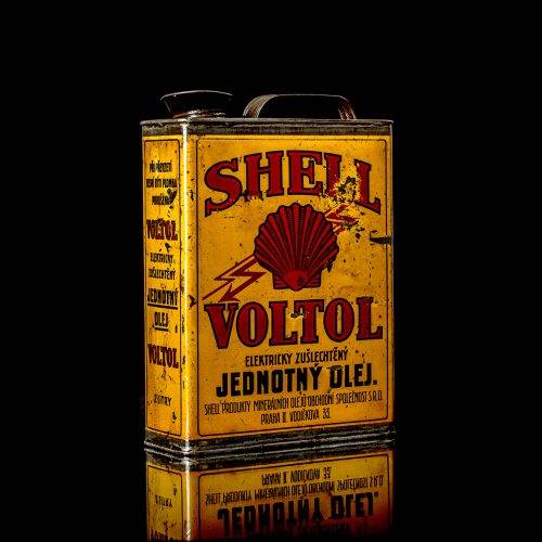 Vintage Shell oil cans with red and yellow branding from the 1900-1920 old logo Vintage Shell oil cans from 1900-19255, featuring the old logo. The photo showcases an antique tin red with yellow accents, displaying the historic Shell emblem. Shot in a studio against a solid black background