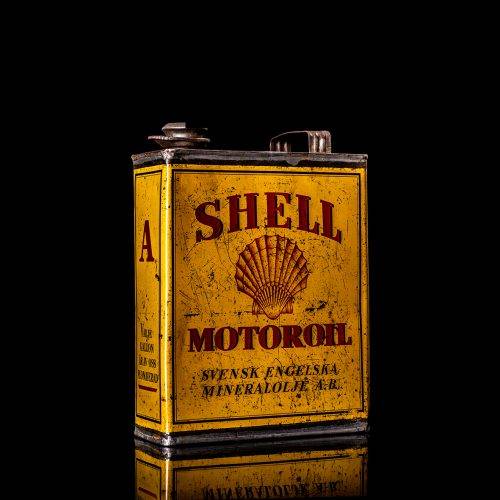 Vintage Shell oil cans with red and yellow branding from the 1900-1920 old logo Vintage Shell oil cans from 1900-19255, featuring the old logo. The photo showcases an antique tin red with yellow accents, displaying the historic Shell emblem. Shot in a studio against a solid black background