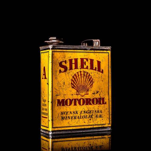 Vintage Shell oil cans with red and yellow branding from the 1900-1920 old logo Vintage Shell oil cans from 1900-19255, featuring the old logo. The photo showcases an antique tin red with yellow accents, displaying the historic Shell emblem. Shot in a studio against a solid black background
