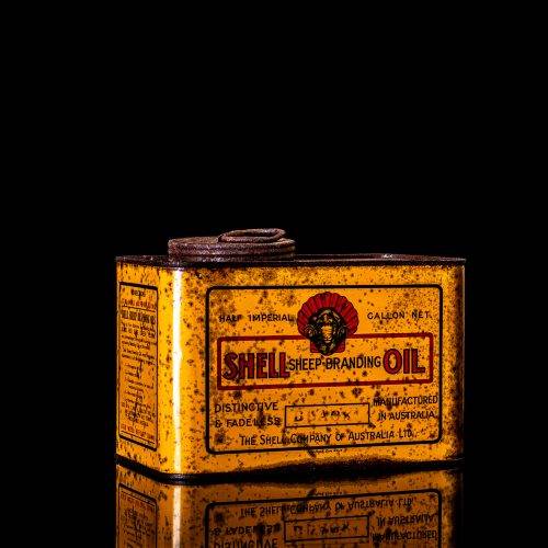 Vintage Shell oil cans with red and yellow branding from the 1900-1920 old logo Vintage Shell oil cans from 1900-19255, featuring the old logo. The photo showcases an antique tin red with yellow accents, displaying the historic Shell emblem. Shot in a studio against a solid black background