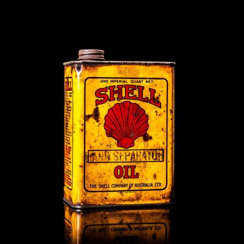 Vintage Shell oil cans with red and yellow branding from the 1900-1920 old logo Vintage Shell oil cans from 1900-19255, featuring the old logo. The photo showcases an antique tin red with yellow accents, displaying the historic Shell emblem. Shot in a studio against a solid black background