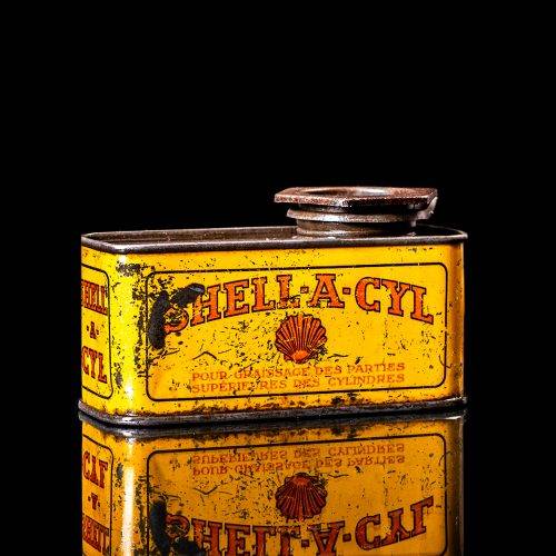 Vintage Shell oil cans with red and yellow branding from the 1900-1920 old logo Vintage Shell oil cans from 1900-19255, featuring the old logo. The photo showcases an antique tin red with yellow accents, displaying the historic Shell emblem. Shot in a studio against a solid black background