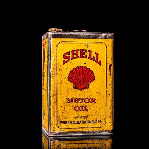 Vintage Shell oil cans with red and yellow branding from the 1900-1920 old logo Vintage Shell oil cans from 1900-19255, featuring the old logo. The photo showcases an antique tin red with yellow accents, displaying the historic Shell emblem. Shot in a studio against a solid black background