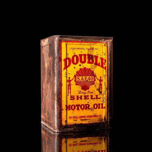 Vintage Shell oil cans with red and yellow branding from the 1900-1920 old logo Vintage Shell oil cans from 1900-19255, featuring the old logo. The photo showcases an antique tin red with yellow accents, displaying the historic Shell emblem. Shot in a studio against a solid black background