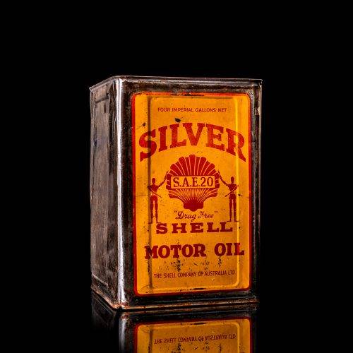 Vintage Shell oil cans with red and yellow branding from the 1900-1920 old logo Vintage Shell oil cans from 1900-19255, featuring the old logo. The photo showcases an antique tin red with yellow accents, displaying the historic Shell emblem. Shot in a studio against a solid black background