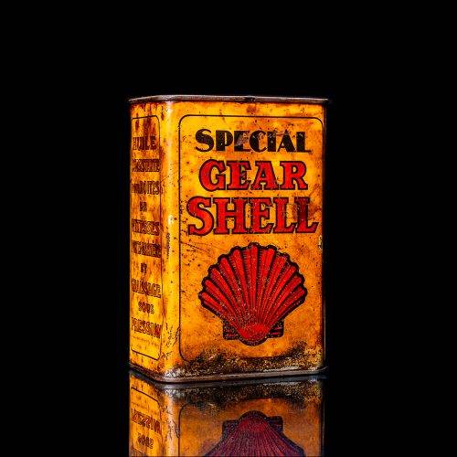 Vintage Shell oil cans with red and yellow branding from the 1900-1920 old logo Vintage Shell oil cans from 1900-19255, featuring the old logo. The photo showcases an antique tin red with yellow accents, displaying the historic Shell emblem. Shot in a studio against a solid black background