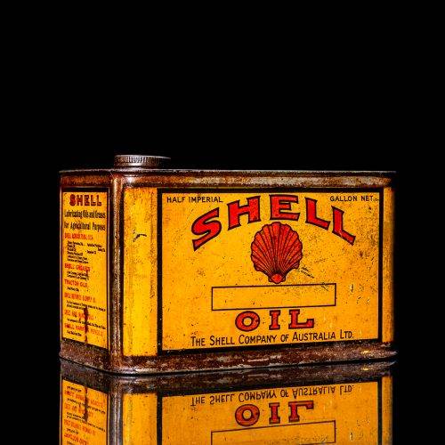 Vintage Shell oil cans with red and yellow branding from the 1900-1920 old logo Vintage Shell oil cans from 1900-19255, featuring the old logo. The photo showcases an antique tin red with yellow accents, displaying the historic Shell emblem. Shot in a studio against a solid black background