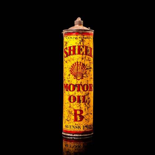 Vintage Shell oil cans with red and yellow branding from the 1900-1920 old logo Vintage Shell oil cans from 1900-19255, featuring the old logo. The photo showcases an antique tin red with yellow accents, displaying the historic Shell emblem. Shot in a studio against a solid black background