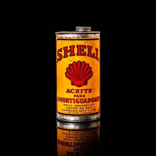 Vintage Shell oil cans with red and yellow branding from the 1900-1920 old logo Vintage Shell oil cans from 1900-19255, featuring the old logo. The photo showcases an antique tin red with yellow accents, displaying the historic Shell emblem. Shot in a studio against a solid black background