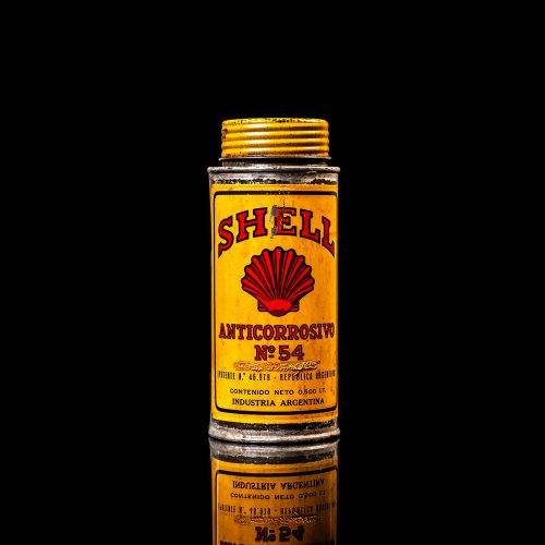 Vintage Shell oil cans with red and yellow branding from the 1900-1920 old logo Vintage Shell oil cans from 1900-19255, featuring the old logo. The photo showcases an antique tin red with yellow accents, displaying the historic Shell emblem. Shot in a studio against a solid black background