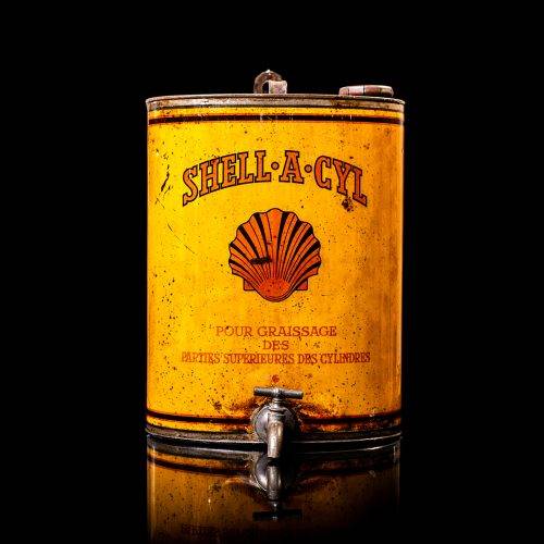 Vintage Shell oil cans with red and yellow branding from the 1900-1920 old logo Vintage Shell oil cans from 1900-19255, featuring the old logo. The photo showcases an antique tin red with yellow accents, displaying the historic Shell emblem. Shot in a studio against a solid black background