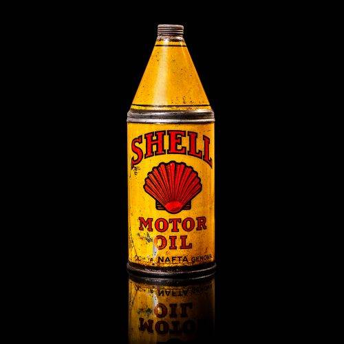 Vintage Shell oil cans with red and yellow branding from the 1900-1920 old logo Vintage Shell oil cans from 1900-19255, featuring the old logo. The photo showcases an antique tin red with yellow accents, displaying the historic Shell emblem. Shot in a studio against a solid black background