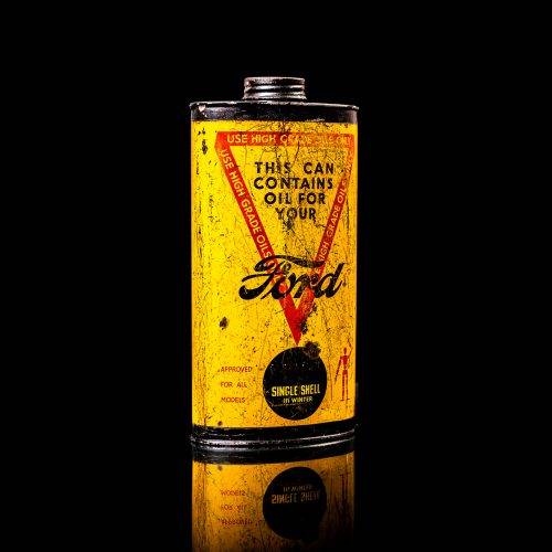 Vintage Shell oil cans with red and yellow branding from the 1900-1920 old logo Vintage Shell oil cans from 1900-19255, featuring the old logo. The photo showcases an antique tin red with yellow accents, displaying the historic Shell emblem. Shot in a studio against a solid black background