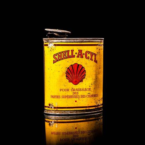 Vintage Shell oil cans with red and yellow branding from the 1900-1920 old logo Vintage Shell oil cans from 1900-19255, featuring the old logo. The photo showcases an antique tin red with yellow accents, displaying the historic Shell emblem. Shot in a studio against a solid black background