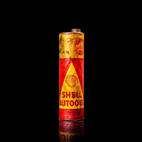 Vintage Shell oil cans with red and yellow branding from the 1900-1920 old logo Vintage Shell oil cans from 1900-19255, featuring the old logo. The photo showcases an antique tin red with yellow accents, displaying the historic Shell emblem. Shot in a studio against a solid black background