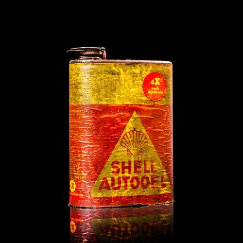 Vintage Shell oil cans with red and yellow branding from the 1900-1920 old logo Vintage Shell oil cans from 1900-19255, featuring the old logo. The photo showcases an antique tin red with yellow accents, displaying the historic Shell emblem. Shot in a studio against a solid black background