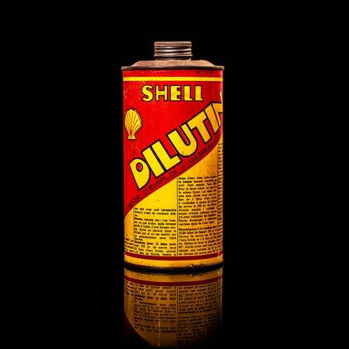 Vintage Shell oil cans with red and yellow branding from the 1900-1920 old logo Vintage Shell oil cans from 1900-19255, featuring the old logo. The photo showcases an antique tin red with yellow accents, displaying the historic Shell emblem. Shot in a studio against a solid black background