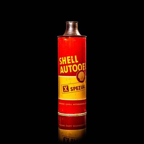 Vintage Shell oil cans with red and yellow branding from the 1900-1920 old logo Vintage Shell oil cans from 1900-19255, featuring the old logo. The photo showcases an antique tin red with yellow accents, displaying the historic Shell emblem. Shot in a studio against a solid black background