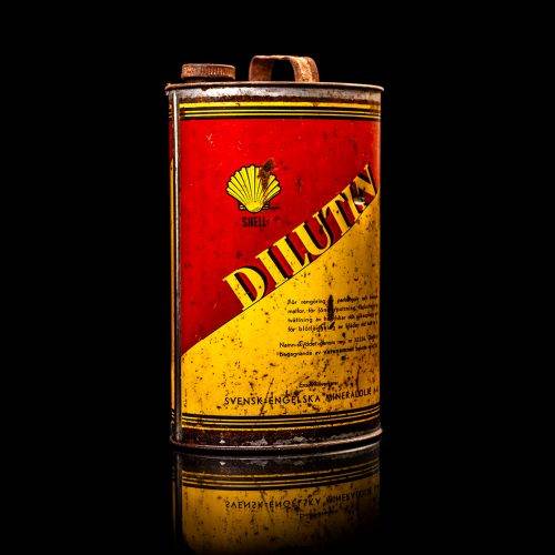 Vintage Shell oil cans with red and yellow branding from the 1900-1920 old logo Vintage Shell oil cans from 1900-19255, featuring the old logo. The photo showcases an antique tin red with yellow accents, displaying the historic Shell emblem. Shot in a studio against a solid black background