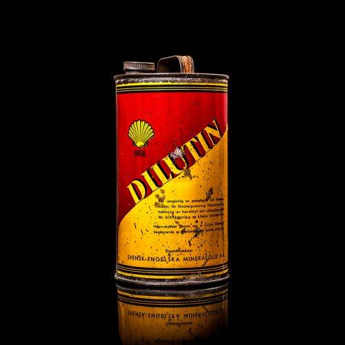 Vintage Shell oil cans with red and yellow branding from the 1900-1920 old logo Vintage Shell oil cans from 1900-19255, featuring the old logo. The photo showcases an antique tin red with yellow accents, displaying the historic Shell emblem. Shot in a studio against a solid black background