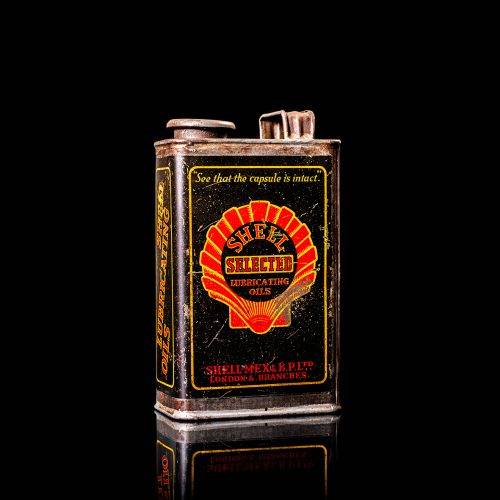 Vintage Shell oil cans with red and yellow branding from the 1900-1920 old logo Vintage Shell oil cans from 1900-19255, featuring the old logo. The photo showcases an antique tin red with yellow accents, displaying the historic Shell emblem. Shot in a studio against a solid black background