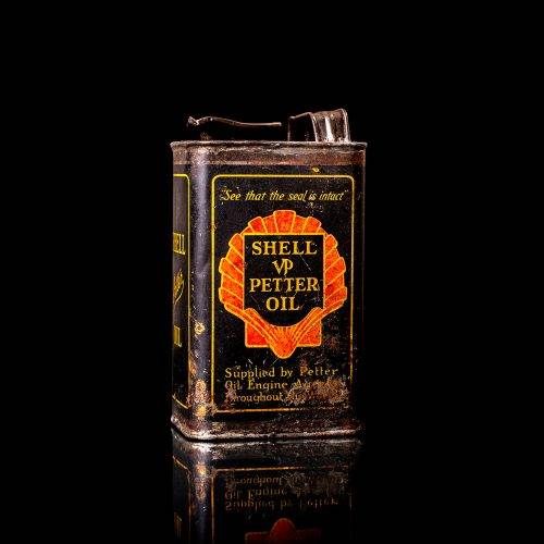 Vintage Shell oil cans with red and yellow branding from the 1900-1920 old logo Vintage Shell oil cans from 1900-19255, featuring the old logo. The photo showcases an antique tin red with yellow accents, displaying the historic Shell emblem. Shot in a studio against a solid black background