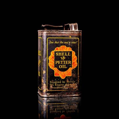 Vintage Shell oil cans with red and yellow branding from the 1900-1920 old logo Vintage Shell oil cans from 1900-19255, featuring the old logo. The photo showcases an antique tin red with yellow accents, displaying the historic Shell emblem. Shot in a studio against a solid black background