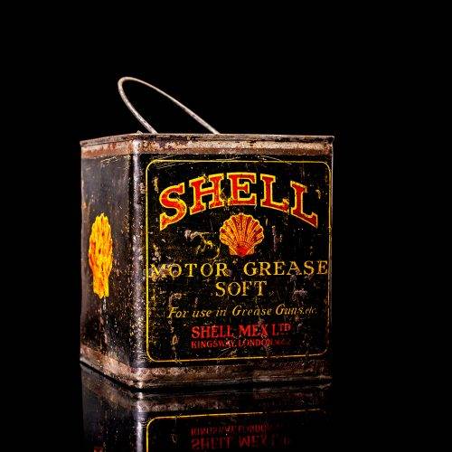 Vintage Shell oil cans with red and yellow branding from the 1900-1920 old logo Vintage Shell oil cans from 1900-19255, featuring the old logo. The photo showcases an antique tin red with yellow accents, displaying the historic Shell emblem. Shot in a studio against a solid black background